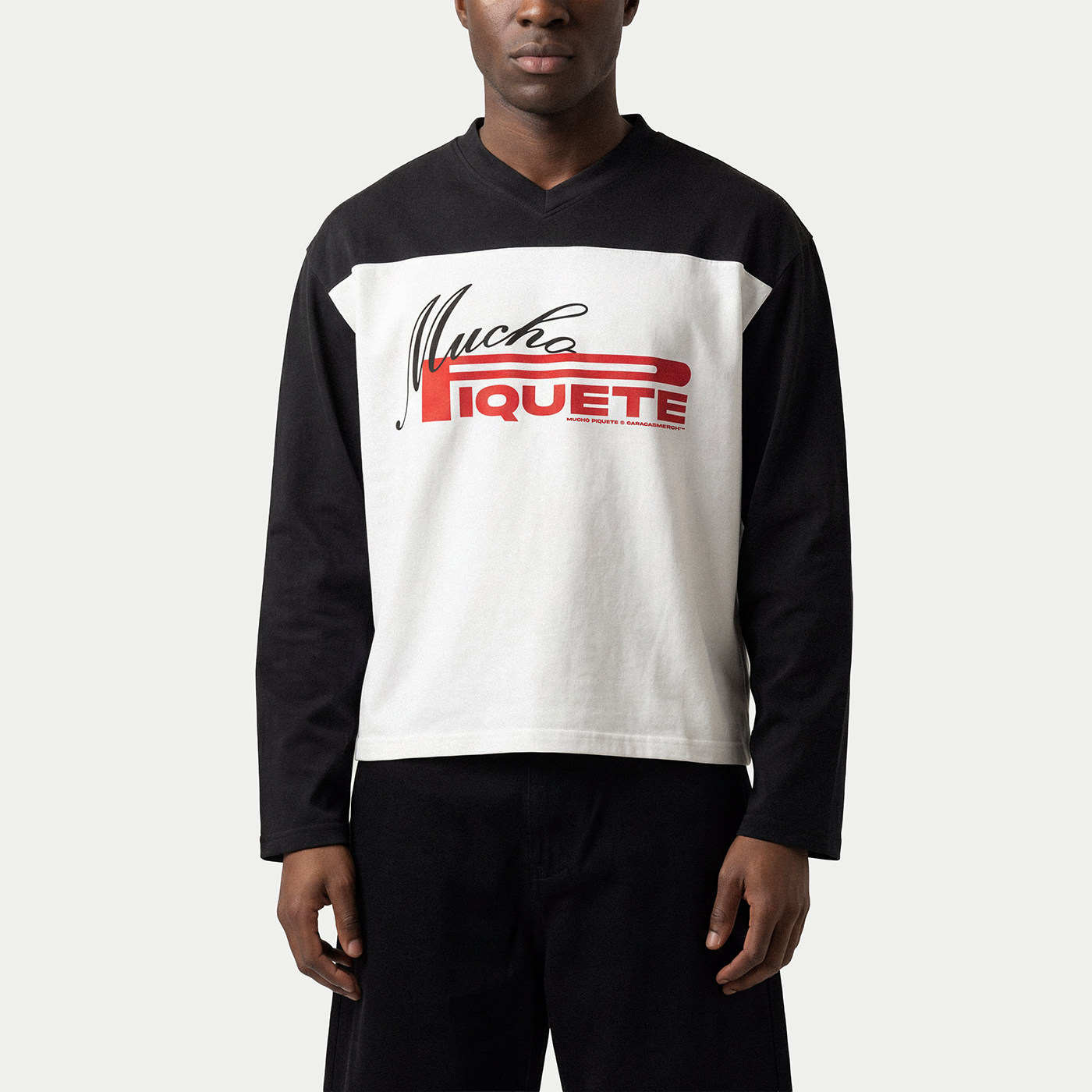 Model wearing the Mucho Piquete white long sleeve tee by Caracas Merch